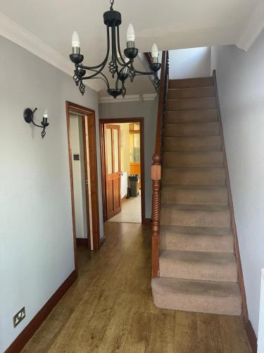 a hallway with a staircase with a chandelier at Shared house on Southmead in Bristol