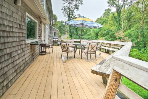 a deck with a table and chairs and an umbrella at Falmouth Retreat with Deck and Grill, Walk to Beaches! in Falmouth