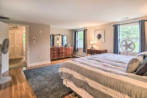 a bedroom with a large bed and a large window at Falmouth Retreat with Deck and Grill, Walk to Beaches! in Falmouth