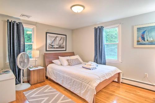 a bedroom with a bed and two windows at Falmouth Retreat with Deck and Grill, Walk to Beaches! in Falmouth