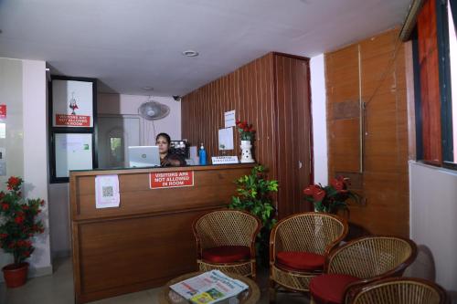 Collection O Safe Hotel Kadavanthra في إرناكولام: امرأة تقف في كونتر صالون