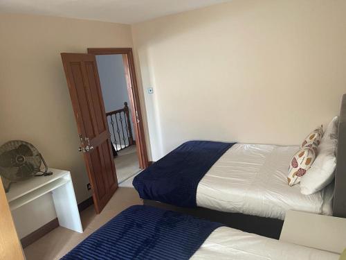a bedroom with two beds and a door to a hallway at Shared house on Southmead in Bristol