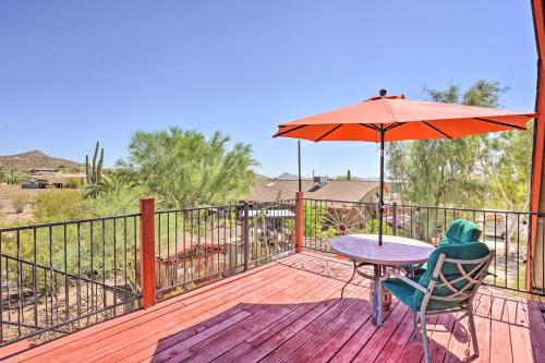 eine Terrasse mit einem Tisch und einem Sonnenschirm auf einem Deck in der Unterkunft Dreamy Desert Studio with Deck and Pool Access! in Phoenix