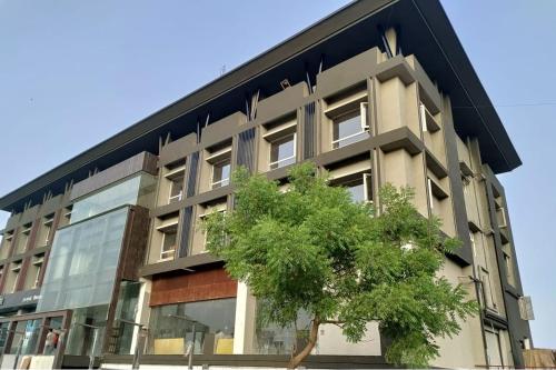 an apartment building with a tree in front of it at Spree Hotel Aurangabad in Aurangabad