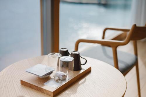 a wooden table with two cups and a glass on it at Entô in Ama