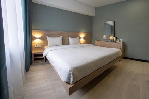 una camera da letto con un grande letto bianco con due cuscini di Resident Hotel Kazybek Bi a Almaty