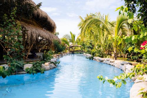 a swimming pool in a resort with palm trees at Lang's Pá Mé - Homestay - Bungalow - Camping Krông Pắk, Buôn Mê Thuột, Đắk Lắk, Việt Nam in Dak Lak