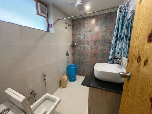 uma casa de banho com um lavatório, um WC e um chuveiro em Sangita Resorts em Nainital