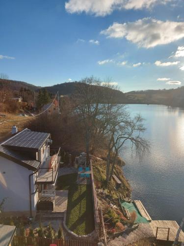 a view of a body of water with a house at Chata pri Veľkom Kolpašskom tajchu in Banský Studenec