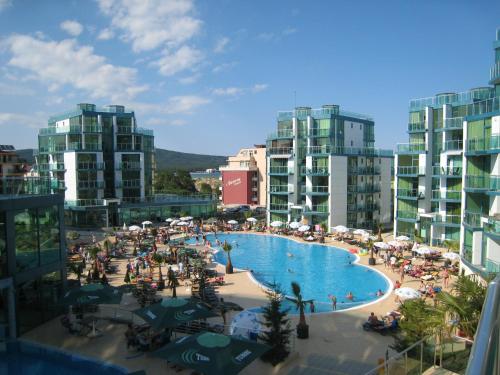 a view of a swimming pool with people and buildings at Apartments in hotel Primorsko Del Sol in Primorsko