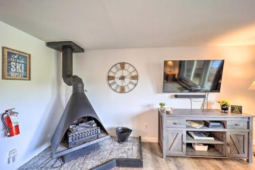 a living room with a stone fireplace and a tv at Walk to Ski Resort! Sugar Mtn Haven with Lake Views in Sugar Mountain