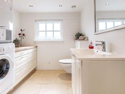 Baño blanco con aseo y lavamanos en Two-Bedroom Holiday home in Otterup 12, en Otterup
