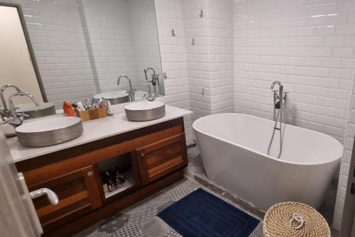 uma casa de banho com 2 lavatórios e uma banheira em Chambre chez l'habitant cosy et moderne, vue sur montagne em Saint-Denis
