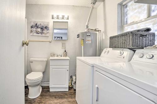 a white bathroom with a toilet and a refrigerator at Low-Key Columbus Apartment - Great Location! in Columbus
