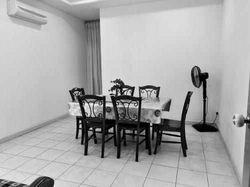 a dining room with a table and eight chairs at Kenyalang Emerald Riverine Resort Homestay in Kuching
