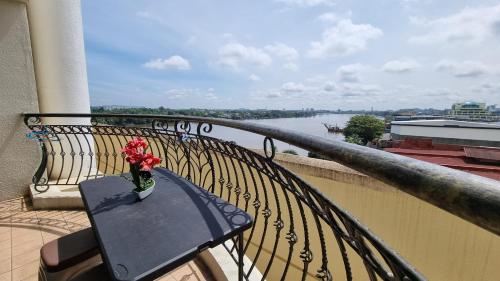 a vase of flowers sitting on a table on a balcony at Kenyalang Emerald Riverine Resort Homestay in Kuching