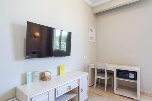 a living room with a tv on the wall at Hotel Villa Emitta in Tomohon