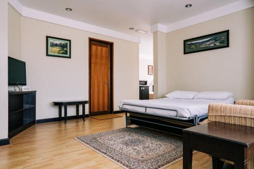 a bedroom with a bed and a table and a television at Hotel De' La Ferns, Cameron Highlands in Cameron Highlands