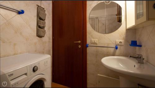 a bathroom with a washing machine and a sink at Airport at 25 min ByWalk-Big Port 10 min by bus-Bus&CommCenter 1 min by walk - 1 min by walk to bus to city and beaches 1 min by walk to touristic port-entire Apartement with 3 indipendent rooms Air cond&WIFI&washMachine till 6 pex AZZURRO in Olbia