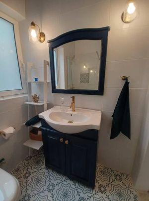a bathroom with a sink and a mirror at Summer Marsalforn Holiday Apartment in Marsalforn