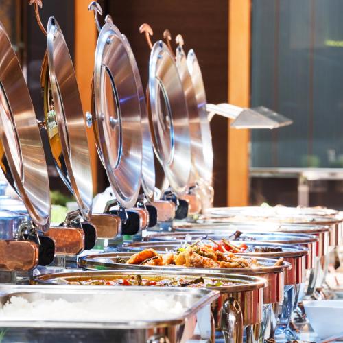a buffet line with many plates of food at La Maison Hotel Doha in Doha