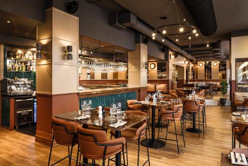 a restaurant with tables and chairs and a bar at Comfort Hotel Linköping City in Linköping