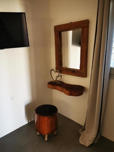a room with a mirror and a stool and a ottoman at Niriides Hotel Apartments in Symi