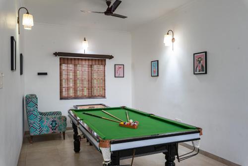 a room with a pool table and a chair at Lavish Executive Villa with Private Swimming Pool in Calangute