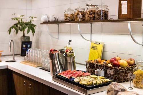 a kitchen counter with a tray of fruits and vegetables at Comfort Hotel Linköping City in Linköping