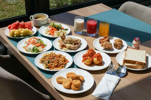 a table with many plates of food on it at Hotel Villa Emitta in Tomohon