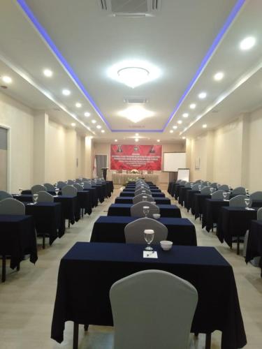 a large room with tables and chairs and a stage at Hotel Villa Emitta in Tomohon