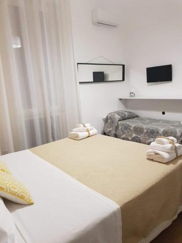 2 łóżka w pokoju hotelowym z ręcznikami w obiekcie Aziz b&b w mieście Palermo