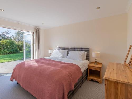 a bedroom with a bed and a large window at Cuil Bay Lodge in Acharra