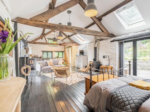 a bedroom with a bed and a living room at The Barn in Newbridge on Wye