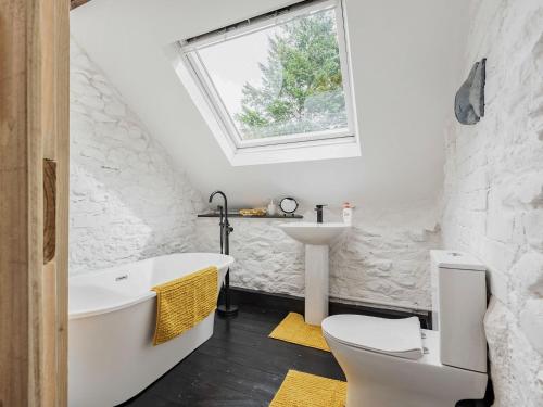 a bathroom with a white tub and a sink at The Barn in Newbridge on Wye