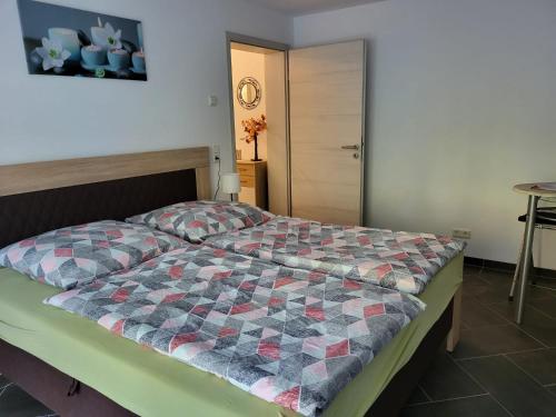 een slaapkamer met een bed met een quilt bij Gästewohnung 1 in Oschersleben