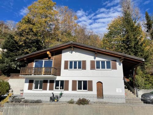 a white house with a balcony on top of it at Casa Campanula in Laax