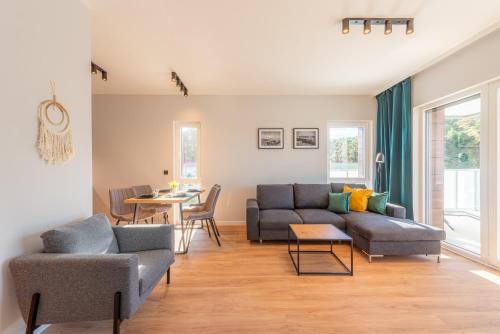 a living room with two couches and a table at Apartamenty Sun Seasons 24 - Baltic Park in Pogorzelica