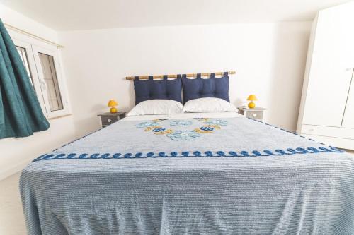カリーニにあるCasa Turramèのベッドルーム1室(大型ベッド1台、青い掛け布団付)