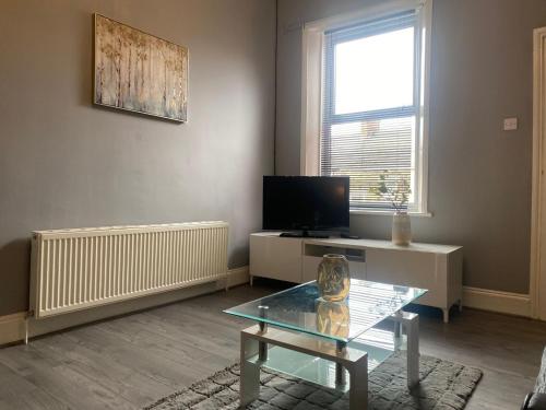 a living room with a coffee table and a television at Alexander Apartments Gateshead 2 in Gateshead