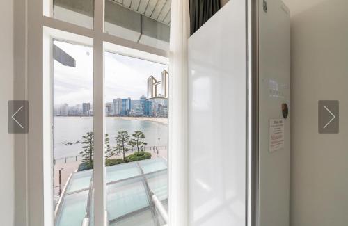 a window in a building with a view of the water at De Homme Hotel in Busan