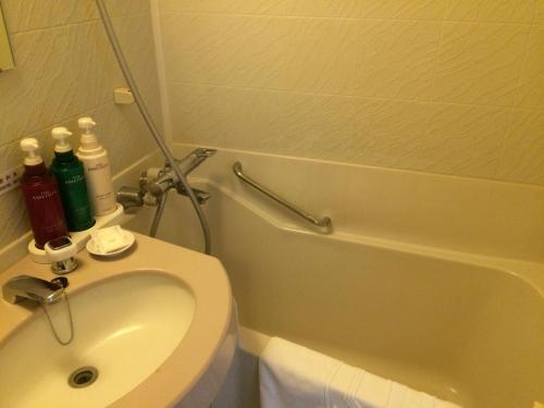 łazienka z toaletą, umywalką i wanną w obiekcie Narita U-City Hotel w mieście Narita