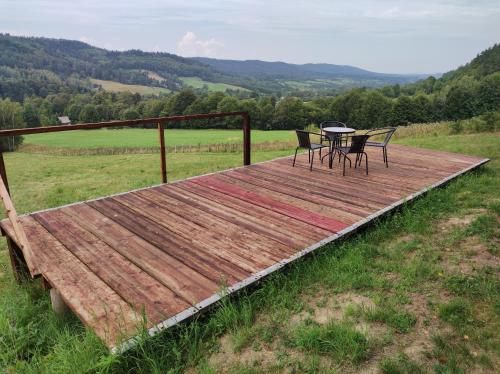a wooden deck with two chairs and a table on it at Rezydencja Bukowy Dwór in Czarna