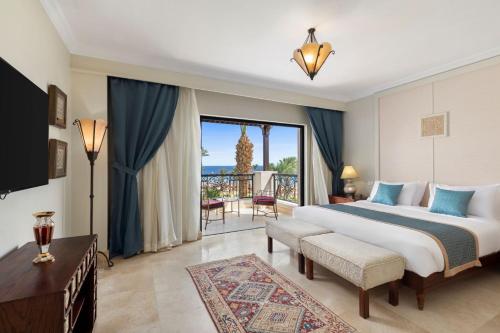 a bedroom with a large bed and a balcony at Pickalbatros The Palace Port Ghalib in Port Ghalib