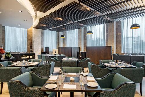 a dining room with tables and chairs and windows at Holiday Inn Amritsar Ranjit Avenue by IHG in Amritsar