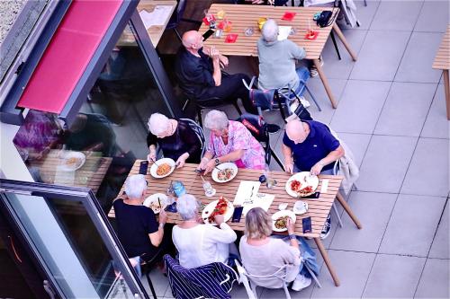 a group of people sitting at a table eating food at Hotel Credé in Kassel