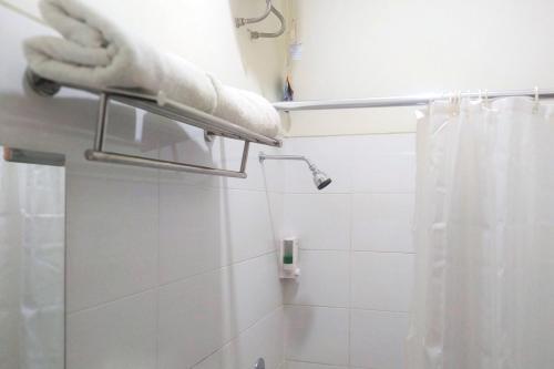 baño con ducha con cortina blanca en Residence 6 en Yakarta