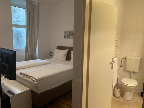 1 dormitorio con cama, aseo y ventana en Grand Central Station Apartments I contactless check-in, en Viena