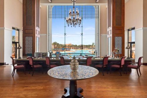 a dining room with a table and a pool at Pickalbatros The Palace Port Ghalib in Port Ghalib