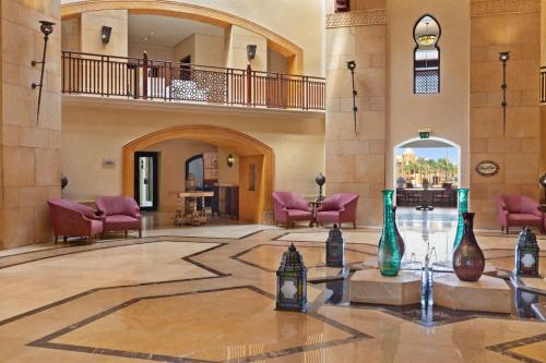 a lobby with purple chairs and vases on the floor at Pickalbatros The Palace Port Ghalib in Port Ghalib